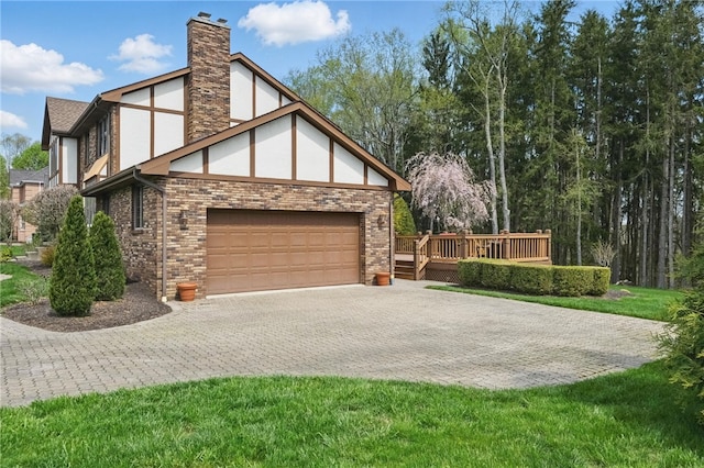 1058 Rimrock Rd, City Of Greensburg, PA 15601 - view of side of property featuring a chimney, a wooden deck, decorative driveway, an attached garage, and stucco siding