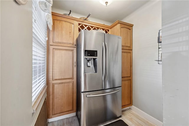 kitchen with stainless steel refrigerator with ice dispenser, baseboards, and light wood-type flooring
