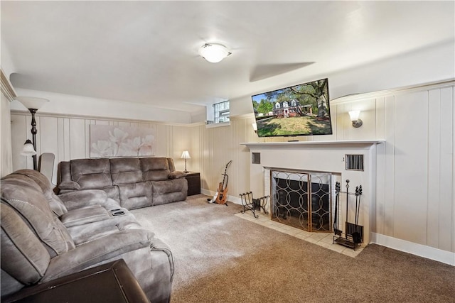 carpeted living room with a fireplace with flush hearth, a decorative wall, and visible vents