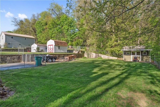 view of yard with fence, an outbuilding, and a storage unit