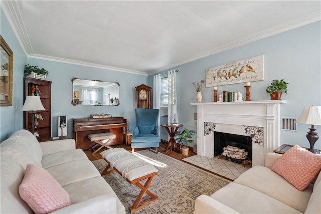 living area featuring crown molding, wood finished floors, visible vents, and a fireplace