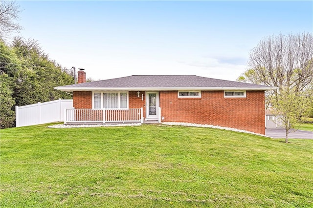 ranch-style house with brick siding, a front lawn, fence, and a chimney