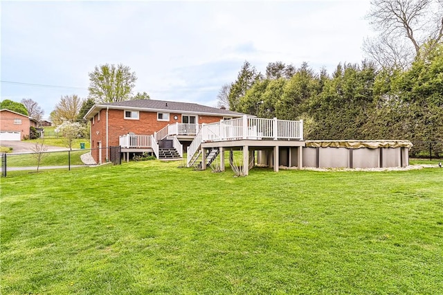 rear view of property featuring a covered pool, a deck, fence, a yard, and stairs