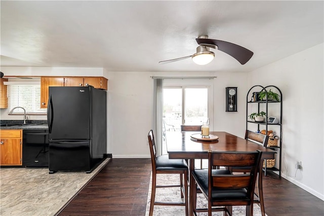 dining space with baseboards, a ceiling fan, and dark wood finished floors