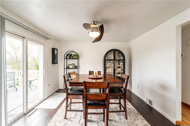 dining area featuring baseboards, ceiling fan, visible vents, and wood finished floors