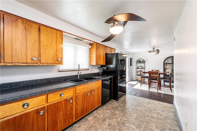 kitchen with dark countertops, ceiling fan, a sink, brown cabinetry, and black appliances
