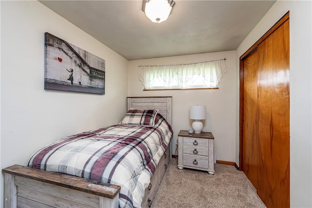 carpeted bedroom with a closet and baseboards