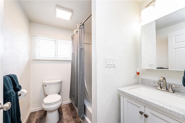 bathroom featuring vanity, toilet, shower / bathtub combination with curtain, baseboards, and wood finished floors