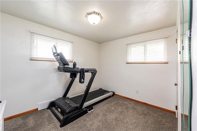 exercise room with visible vents, carpet, and baseboards