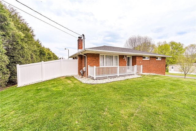 ranch-style home with fence, a front lawn, brick siding, a chimney, and covered porch