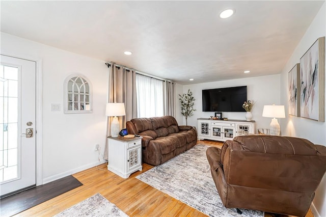 living area featuring recessed lighting, baseboards, and light wood-type flooring