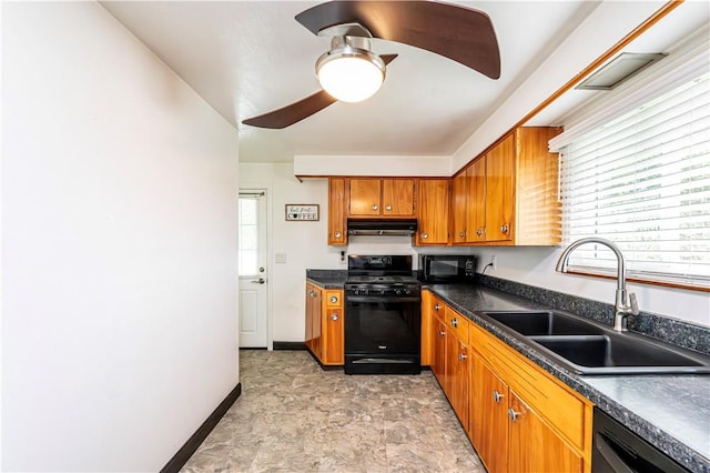 kitchen with ceiling fan, under cabinet range hood, brown cabinets, a sink, and black appliances