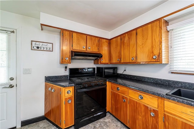kitchen with under cabinet range hood, brown cabinetry, a healthy amount of sunlight, and black appliances