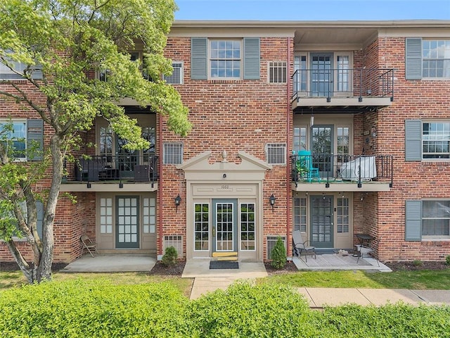 back of property with brick siding and french doors