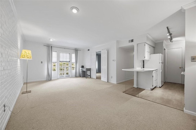 unfurnished living room with baseboards, visible vents, and light carpet
