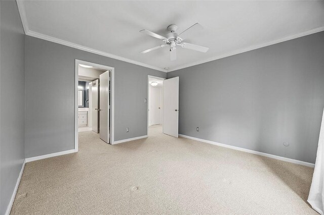 unfurnished bedroom with connected bathroom, ceiling fan, light colored carpet, baseboards, and ornamental molding