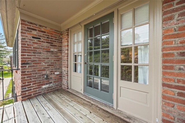 doorway to property with brick siding and covered porch