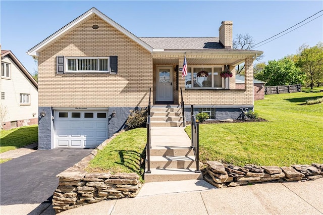 view of front of property with an attached garage, aphalt driveway, brick siding, a front yard, and a chimney