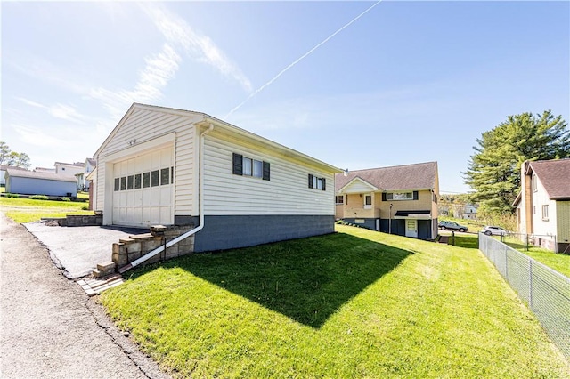 view of home's exterior featuring fence, an outdoor structure, a yard, and a garage