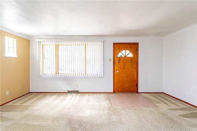 carpeted foyer with baseboards and visible vents