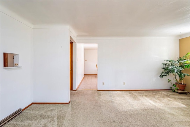 carpeted spare room featuring baseboards
