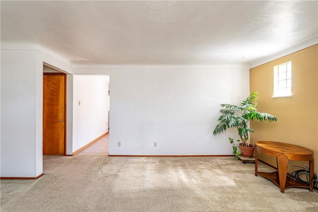carpeted spare room featuring baseboards