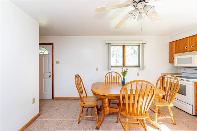 dining space with light tile patterned flooring, ceiling fan, and baseboards