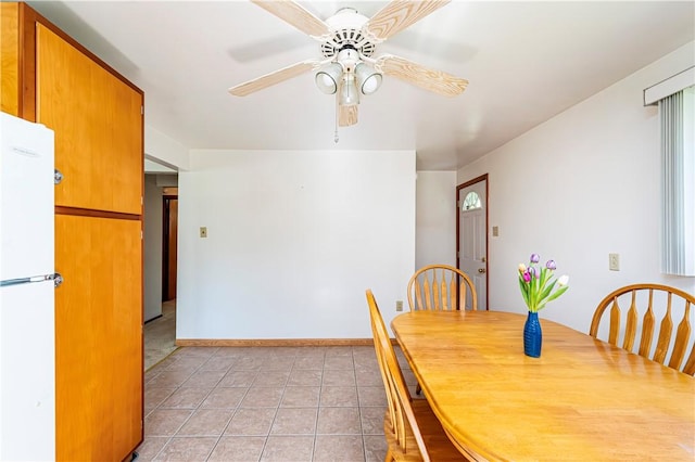 dining area with a ceiling fan, baseboards, and light tile patterned floors