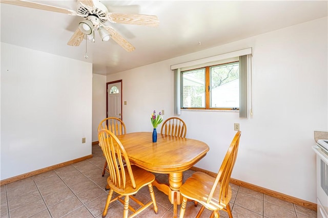 dining space featuring baseboards, a ceiling fan, and light tile patterned flooring