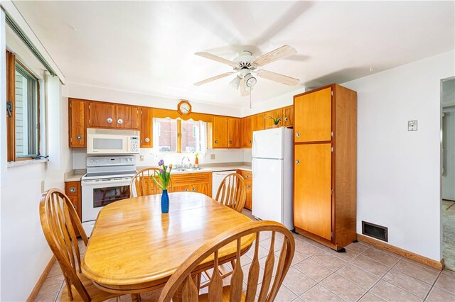 dining area featuring light tile patterned floors, baseboards, ceiling fan, and visible vents