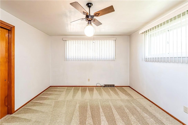 unfurnished room with carpet flooring, ceiling fan, plenty of natural light, and baseboards