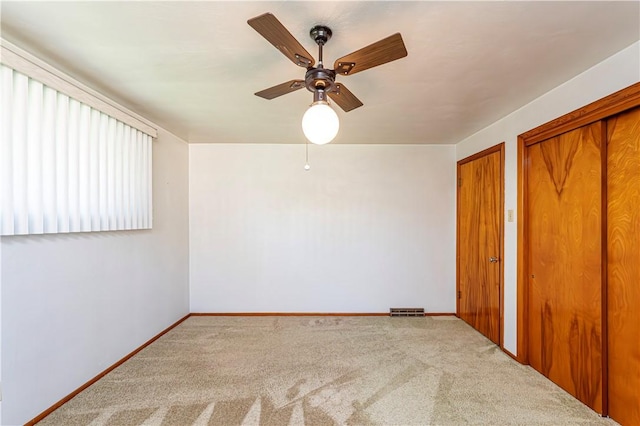 unfurnished bedroom with carpet floors, a ceiling fan, baseboards, and visible vents