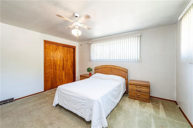 carpeted bedroom featuring baseboards, ceiling fan, a closet, and visible vents