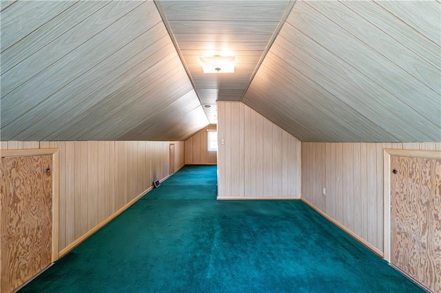 additional living space with carpet, lofted ceiling, and wooden walls