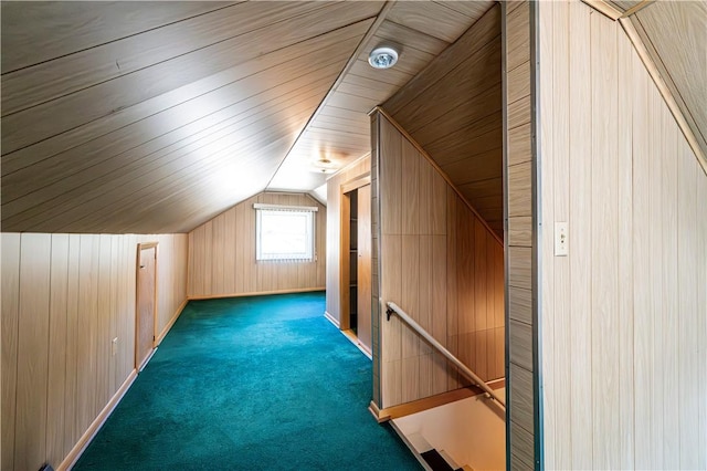 bonus room featuring wooden walls, carpet floors, baseboards, and vaulted ceiling
