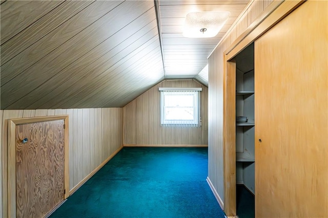 additional living space with carpet floors, wood walls, and vaulted ceiling