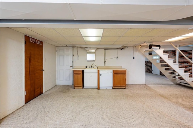below grade area with light colored carpet, a paneled ceiling, and stairway