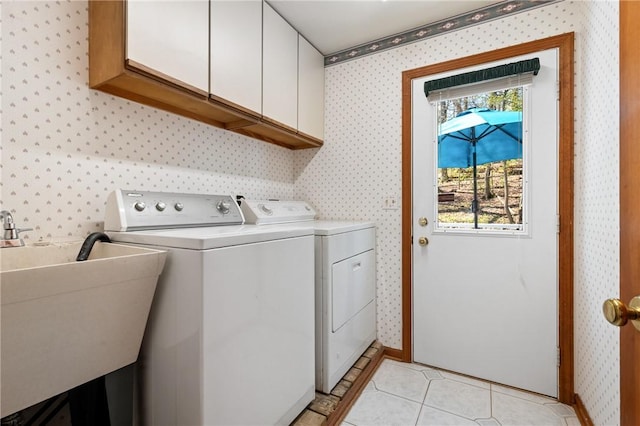 washroom featuring cabinet space, independent washer and dryer, wallpapered walls, and a sink