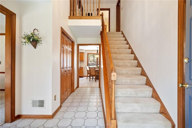 entrance foyer with stairs, baseboards, and visible vents