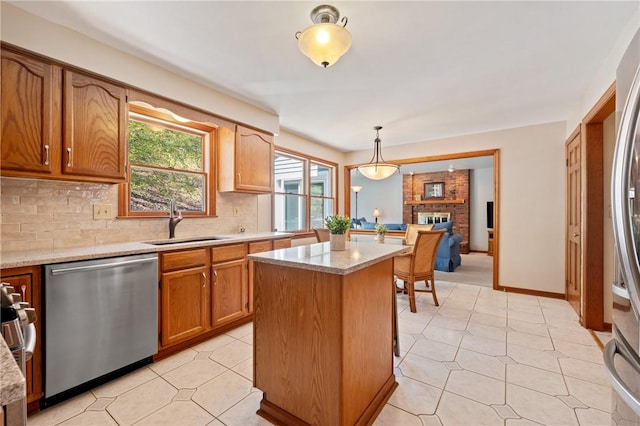 kitchen with a kitchen island, pendant lighting, appliances with stainless steel finishes, tasteful backsplash, and a sink