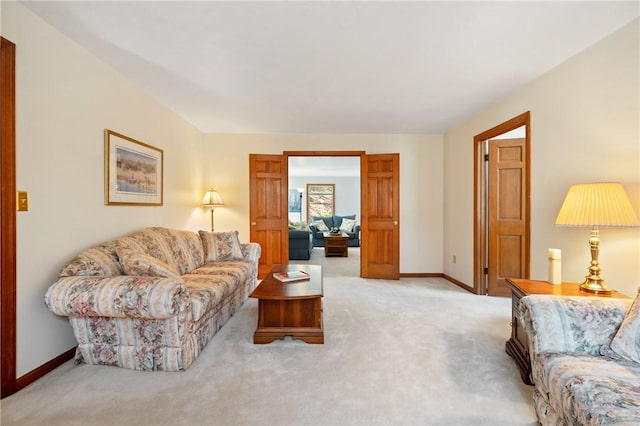 carpeted living area featuring baseboards