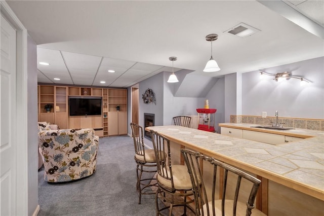 interior space with hanging light fixtures, a sink, carpet, recessed lighting, and visible vents