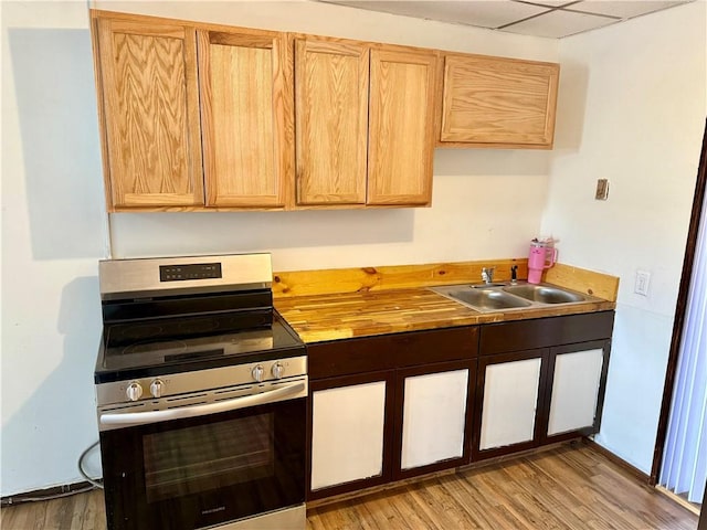 kitchen featuring a sink, electric range, butcher block counters, and light wood finished floors