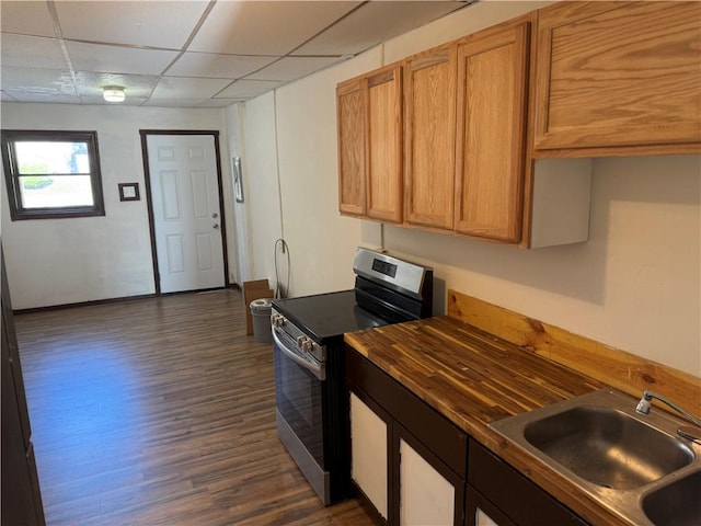 kitchen featuring brown cabinetry, a sink, dark wood-style floors, electric stove, and a drop ceiling