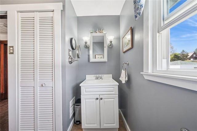 bathroom featuring baseboards, visible vents, a closet, and vanity