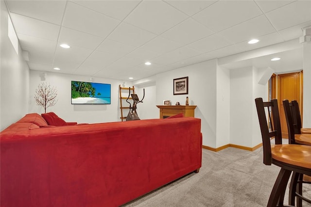 living room featuring light colored carpet, recessed lighting, baseboards, a drop ceiling, and a bar