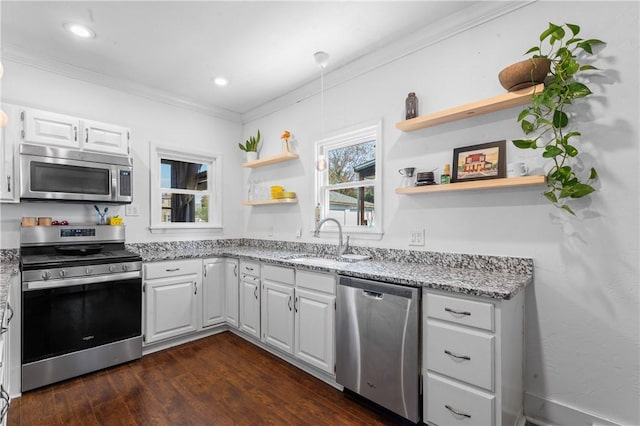 kitchen featuring open shelves, ornamental molding, light stone countertops, a sink, and appliances with stainless steel finishes