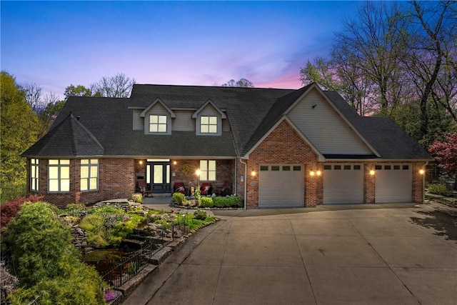cape cod home with concrete driveway, brick siding, and an attached garage