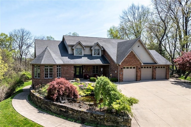 cape cod home featuring an attached garage, a shingled roof, brick siding, and concrete driveway