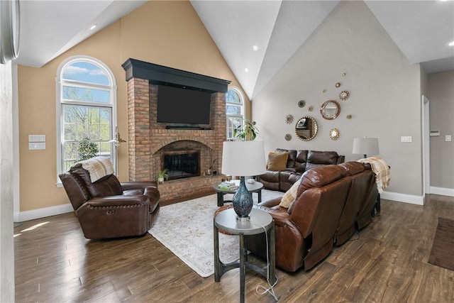 living room featuring baseboards, a brick fireplace, wood finished floors, and high vaulted ceiling